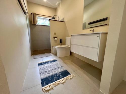 a bathroom with a toilet and a sink and a rug at Superb pool villa 5 bedrooms in Ban Tai