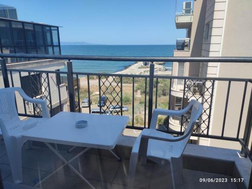 einen weißen Tisch und Stühle auf einem Balkon mit Meerblick in der Unterkunft Apartament Piero in Pomorie