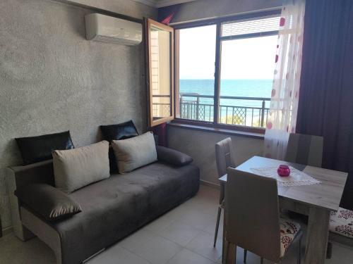 a living room with a couch and a table and a window at Apartament Piero in Pomorie