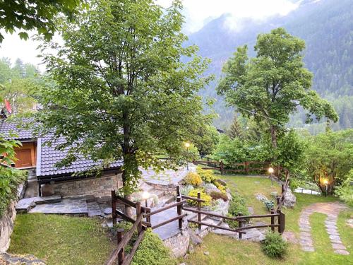 a house with a fence in front of a garden at CHALET A CERESOLE REALE nel Parco Gran Paradiso in Ceresole Reale