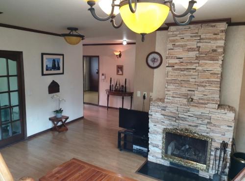 a living room with a stone fireplace and a chandelier at Gabriel Villa in Jeongseon
