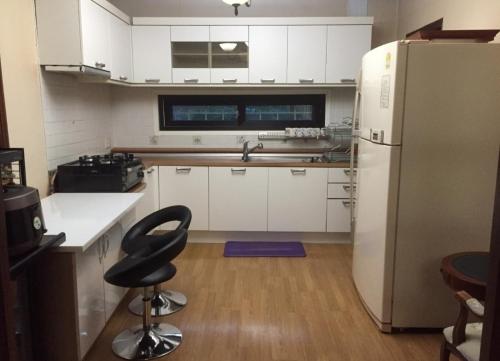 a kitchen with a refrigerator and a chair in it at Gabriel Villa in Jeongseon