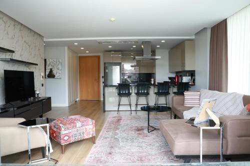 Una sala de estar con un sofá y una cocina. en Lovely Two Bedroom Appartment Istanbul, en Estambul