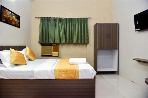 a bedroom with a bed and a green curtain at Bluebells Varanasi in Varanasi
