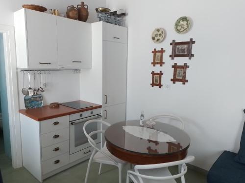 a kitchen with a table and white cabinets at Kalliope sea view summer house in Tripití