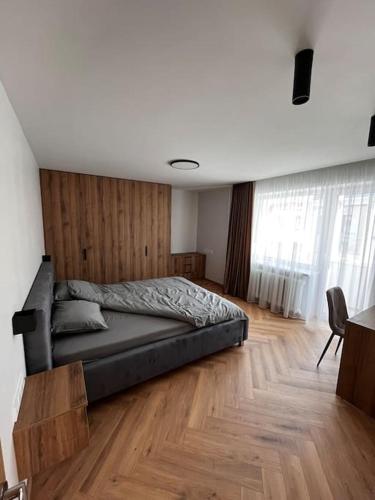 a bedroom with a bed and a wooden floor at Apartment in the old town in Kėdainiai