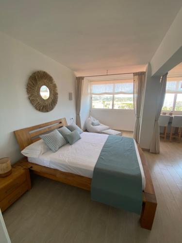 Un dormitorio con una cama y un espejo en la pared. en Saona Sea - Apartamento con vistas en zona arenal, Jávea, en Jávea