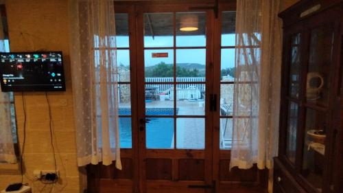 a door with a view of a pool at Ta Ildis B&B in Il-Pergla