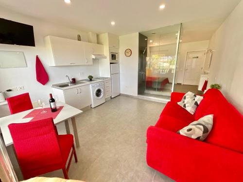 a living room with a red couch and a kitchen at RedVelvet in Tacoronte