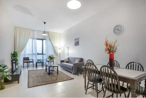 a living room with a couch and a table and chairs at HUGE 3 Bedroom Apartment Beach Front (City View) in Abu Dhabi