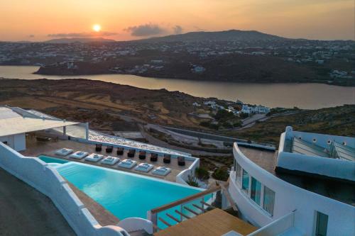 una casa con piscina y vistas a la puesta de sol. en White Stone Mykonos en Agios Ioannis Mykonos