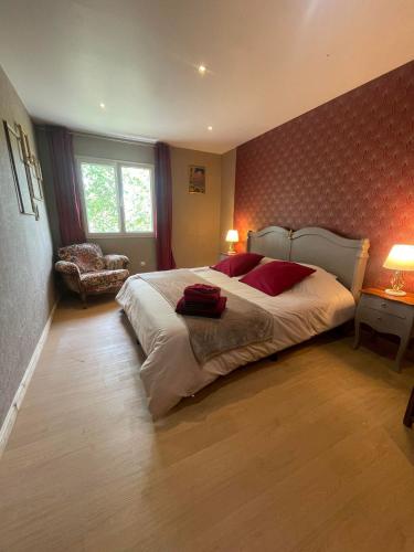 une chambre avec un grand lit blanc avec des oreillers rouges dans l'établissement L'étape Marceline - Chambre D'hôtes, à Saint-Marceau
