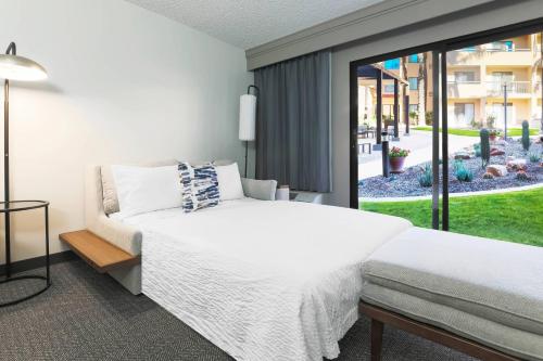 a bedroom with a bed and a large window at Courtyard Tucson Airport in Tucson