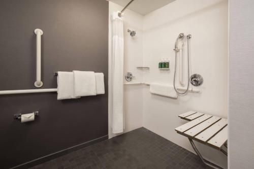 a bathroom with a bench and a shower with towels at Courtyard Tucson Airport in Tucson