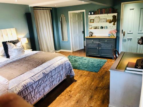a bedroom with a bed and a desk and a desk at Heydon Guest Suite in Heydon