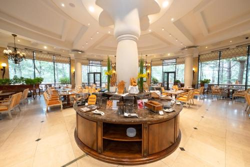 een restaurant met tafels en stoelen in een grote kamer bij Dalat Edensee Lake Resort & Spa in Da Lat