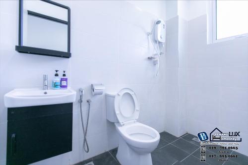 a bathroom with a toilet and a sink and a mirror at 15BR SwimmingPool Villa Golf View Snooker BBQ in Bayan Lepas