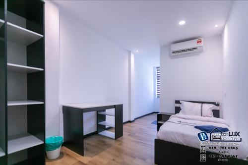 a small bedroom with a bed and a desk at 15BR SwimmingPool Villa Golf View Snooker BBQ in Bayan Lepas