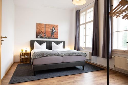 a bedroom with a bed and two windows at Apartments an der Oper - Innenstadt - Zentral - Küche - Wifi - Powered by Ko-Living in Halle an der Saale