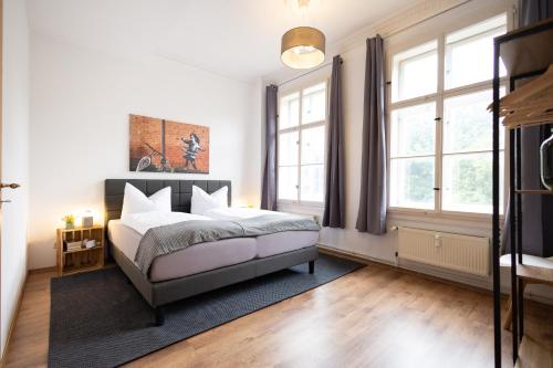 a bedroom with a bed and two windows at Apartments an der Oper - Innenstadt - Zentral - Küche - Wifi - Powered by Ko-Living in Halle an der Saale