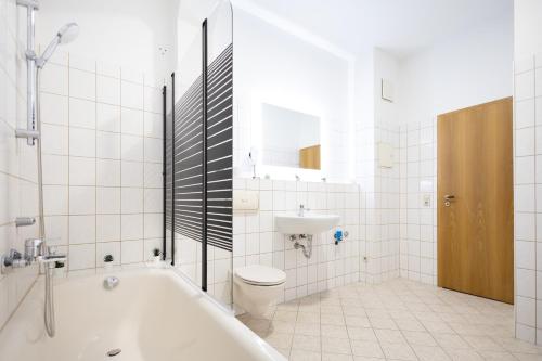 a bathroom with a tub and a toilet and a sink at Apartments an der Oper - Innenstadt - Zentral - Küche - Wifi - Powered by Ko-Living in Halle an der Saale