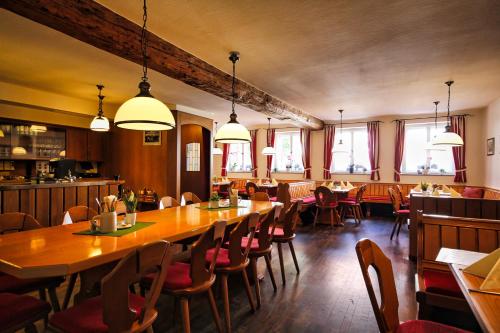 a restaurant with a large wooden table and chairs at Hotel-Gasthof Postbräu Dingolfing in Dingolfing
