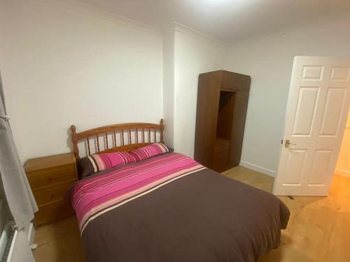 1 dormitorio con 1 cama grande con almohadas rosas en Steps Away from All the Action, en Edimburgo