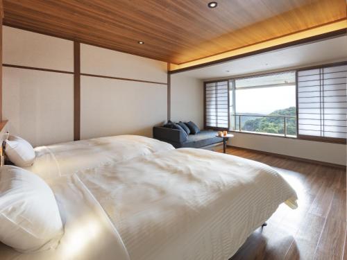 a bedroom with a large white bed and a window at Azumakan in Nihommatsu