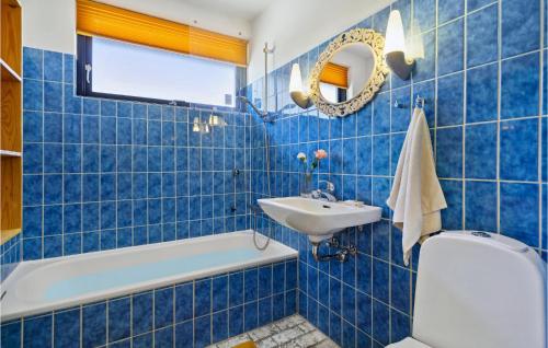 Baño de azulejos azules con aseo y lavamanos en 3 Bedroom Nice Home In Risskov en Risskov