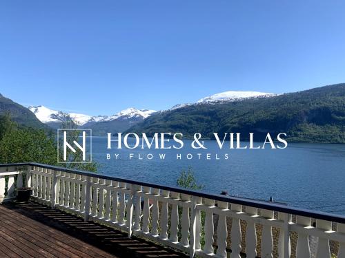 a sign for homes and villas on a bridge over a lake at Faleide Panorama by Homes & Villas in Stryn