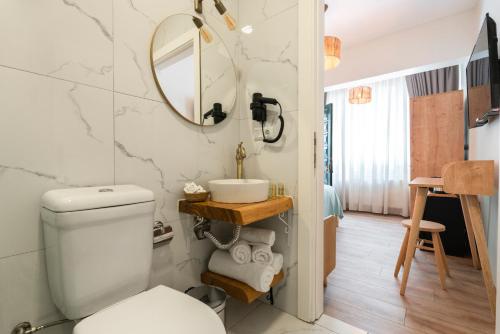 La salle de bains est pourvue de toilettes, d'un lavabo et d'un miroir. dans l'établissement Aya Butik Otel, à Istanbul