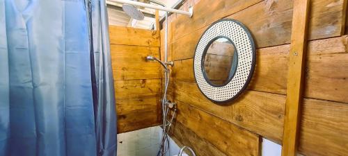 a mirror on a wooden wall in a bathroom at Mobil-home 6 personnes sur terrain 600 m2 in Vias