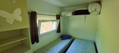 a small room with a window and a bed in it at Mobil-home 6 personnes sur terrain 600 m2 in Vias