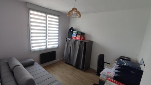 ein Wohnzimmer mit einem Sofa und einem Fenster in der Unterkunft Magnifique maison à 5 mns du circuit des 24h à pieds in Le Mans