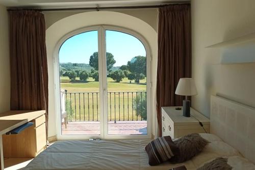 una camera da letto con una grande finestra con vista su un cortile di Casa Los Olivos ad Arcos de la Frontera