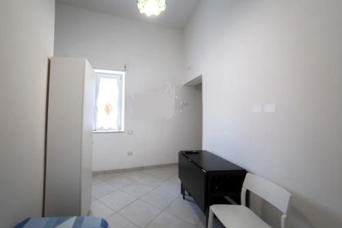 a white room with a black desk and a window at ELISA Dependance Centro in Vietri sul Mare