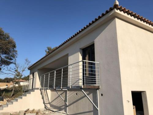 a building with a balcony on the side of it at Villa neuve avec piscine in Bonifacio