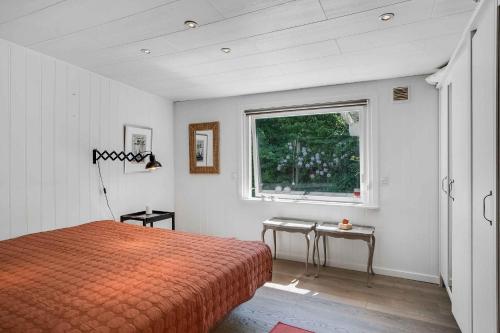 1 dormitorio con cama y ventana en Spacious Cottage With Scenic View en Dronningmølle