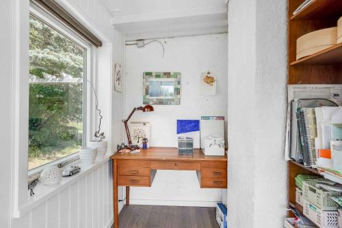 escritorio en una habitación pequeña con ventana en Spacious Cottage With Scenic View en Dronningmølle