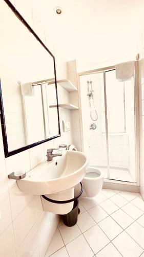 a white bathroom with a sink and a toilet at Villa La Zagara by CapriRooms in Capri