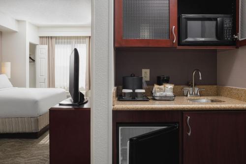 a hotel room with a bed and a kitchen with a sink at SpringHill Suites Knoxville At Turkey Creek in Knoxville