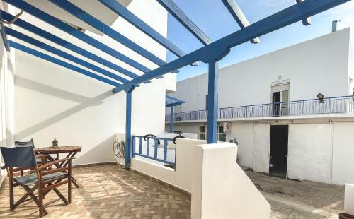 a roof deck with blue beams and a table and chairs at Artemis Bakerys House 2 in Adamas