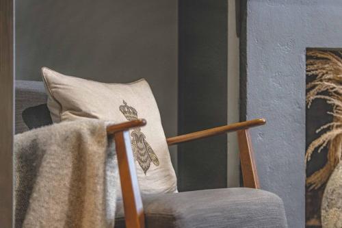 a pillow with a blanket on the back of a chair at Stylish 2-Bed House With Office And Private Garden in Windsor