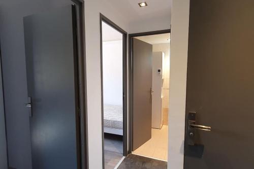 eine Tür, die zu einem Schlafzimmer mit einem Spiegel führt in der Unterkunft Calme, Confortable, Central in Sainte-Maxime