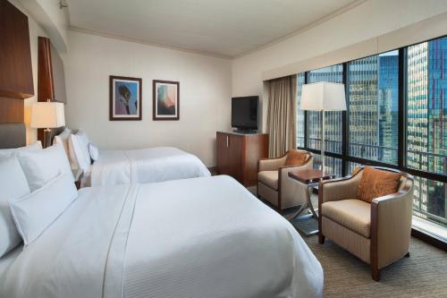 シアトルにあるザ ウェスティン シアトルのベッド2台と大きな窓が備わるホテルルームです。
