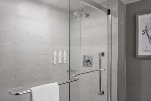 a bathroom with a shower with a glass door at Calgary Marriott Downtown Hotel in Calgary