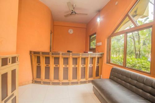 ein Wohnzimmer mit einem Sofa und einem großen Fenster in der Unterkunft Flagship 43145 Mayaban Resort in Ingrāj Bāzār