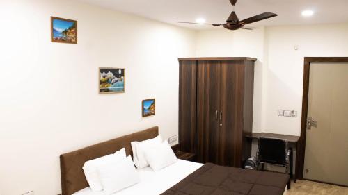 a bedroom with a bed and a ceiling fan at Hotel Kiwi Inn in Indore