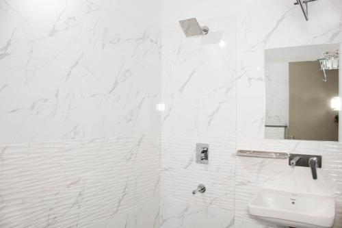 印多爾的住宿－Hotel Kiwi Inn，白色的浴室设有水槽和镜子