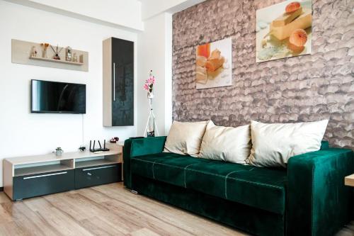 a living room with a green couch and a wall at Aqua Vista Fratelli - Vedere Top la Mare si Lac - Summerland in Mamaia